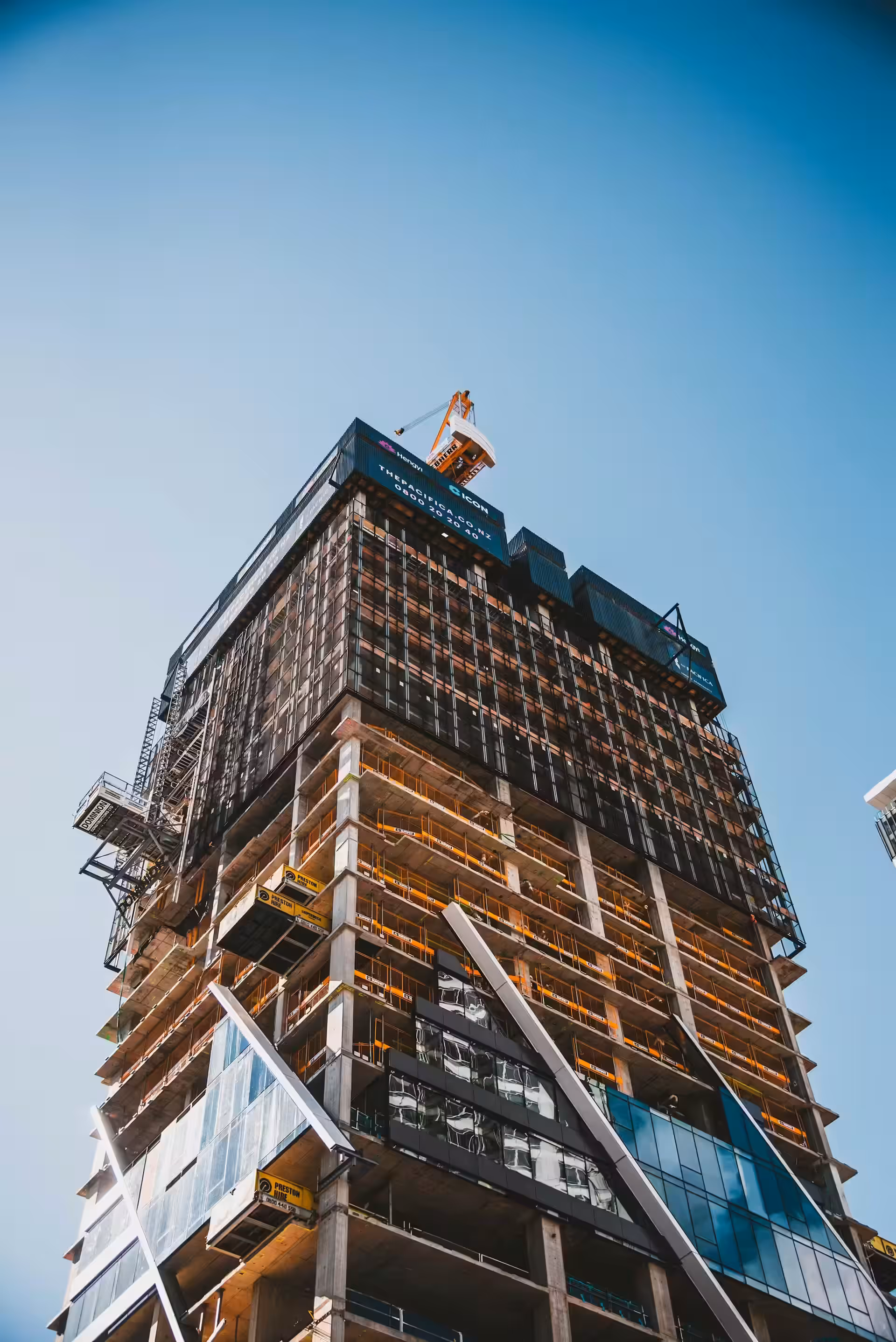 Workers installing ceiling grid and siding panels in a construction site