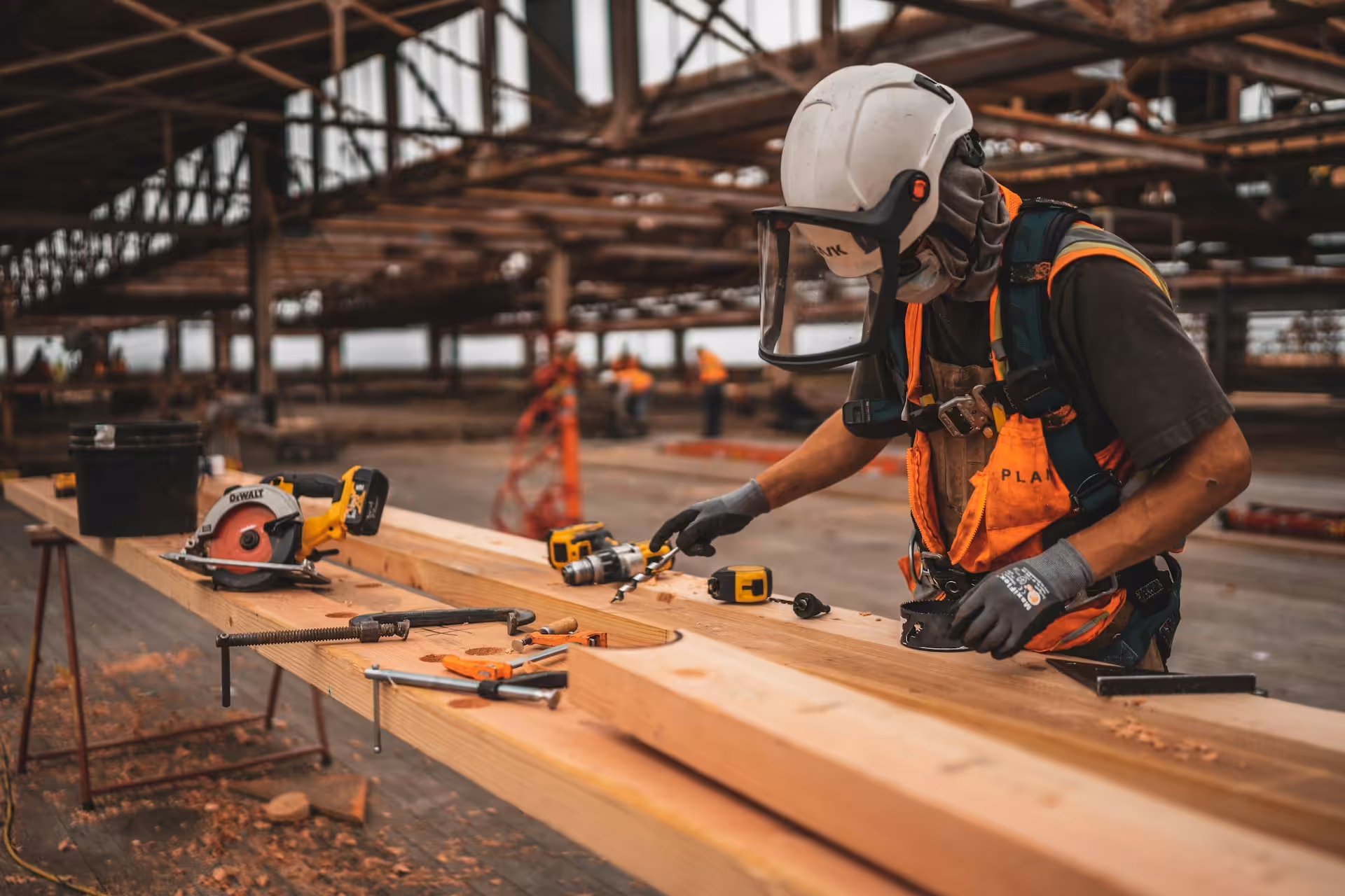 Construction worker in safety gear using professional tools
